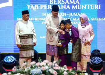 ANWAR Ibrahim menyampaikan sumbangan pada kanak-kanak pada Majlis Berbuka Puasa MADANI Peringkat Negeri Perak di Sekolah Kebangsaan Dato’ Alauddin, Selinsing di Bagan Serai. - UTUSAN/MUHAMAD NAZREEN SYAH MUSTHAFA