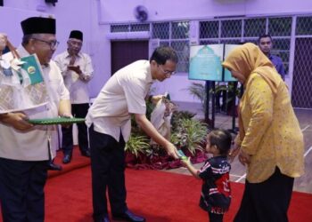 TENGKU Sarafudin Badlishah Sultan Sallehuddin mengurniakan sumbangan kepada seorang kanak-kanak pada Majlis Penyampaian Sumbangan Aidilfitri MAIK di Guar Chempedak, Yan, Kedah.