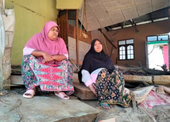 NORAINI Nawi (kanan) bersama kakaknya tetap bertahan tinggal di 
dalam rumah yang runtuh di Kampung Jubakar Pantai, Tumpat, Kelantan. – UTUSAN/ROHANA ISMAIL