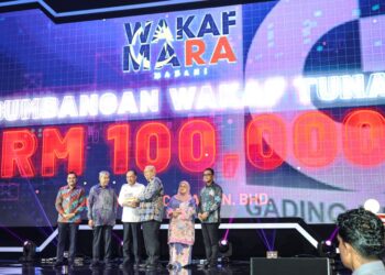 ANWAR Ibrahim menyampaikan trofi kepada Muhamad Guntor Mansor Tobeng selepas menyumbang RM100,000 untuk tabung wakaf bersempena Majlis Peluncuran Wakaf Madani Mara sempena sambutan Hari Majlis Amanah Rakyat (Mara) ke-59 di Pusat Dagangan Dunia Kuala Lumpur (WTCKL), semalam.-UTUSAN/AMIR KHALID