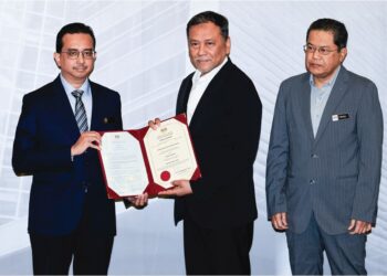 RAMLAN Harun menyampaikan Watikah Pelantikan Pegawai Pengurus Pilihan Raya kepada Pegawai Daerah Batang Padang, Ahmad Redhauddin Ahmad Shokori di Putrajaya, semalam. – UTUSAN/FAIZ ALIF ZUBIR