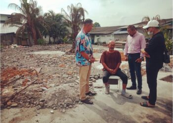 HASHIM Sapap (duduk) menerima kunjungan tetamu yang memberi sumbangan di hadapan rumahnya yang terbakar dekat Kampung Sungai Udang, di Klang, Selangor.