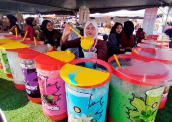 SURIANE Abdullah menyediakan minuman yang dipesan pelanggan di Bazar Ramadan Kuala Besut, Terengganu. - UTUSAN / WAN ZURATIKAH IFFAH WAN ZULKIFLI
