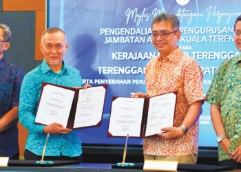 BURHANUDDIN Hilmi Mohamed @ Harun (dua dari kanan) menunjukkan dokumen perjanjian pengurusan dan pengoperasian Jambatan Angkat Kuala Terengganu di Kuala Terengganu, semalam. 
– UTUSAN/KAMALIZA KAMARUDDIN