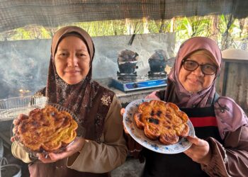 ROHIMIE Ismail@Nik (kanan) dan Maziah Che Ismail menunjukkan kuih Penganan Warisan yang dihasilkan mereka di Kampung Jerangau Sungai, Dungun, Terengganu. – UTUSAN/NIK NUR IZZATUL HAZWANI NIK ADNAN