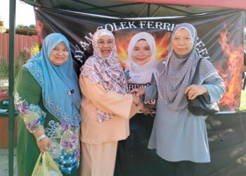 WAN Maimunah Wan Abdul Aziz bergambar bersama peminat di gerai ayam golek Ferris Wheel di Kampung Wakaf Beruas, Kuala Terengganu, Terengganu.- UTUSAN/KAMALIZA KAMARUDDIN