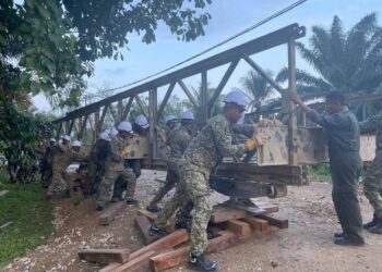 PASUKAN 8 Skuadron Rejimen Askar Jurutera Diraja Tentera Darat Malaysia (TDM) sedang melakukan kerja-kerja pembinaan jambatan sementara sepanjang 18.29 meter di Sungai Tiram.