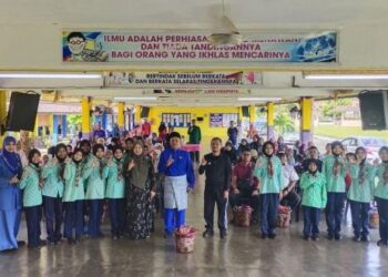 JAMALLUDIN Baharun (berdiri, tengah) bersama guru dan ibu bapa yang menerima sumbangan bakul barang keperluan dapur kepada seorang penjaga murid di Sekolah Kebangsaan Jerantut Jaya, Jerantut, Pahang baru-baru ini.