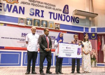 NORAINI Kamaruddin (tengah) menyerahkan plakad kepada Timbalan Pengarah Sektor JPN (Perancangan dan Pengurus Pejabat Pendidikan Daerah), Mat Lazim Mohammad (dua dari kanan) semasa pada Majlis Peluncuran Program Anak Kita di Tunjong, Kota Bharu, Kelantan.