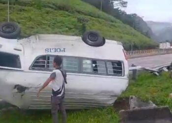 KEADAAN van polis yang terbabas dan terbalik ketika menuruni bukit di Kilometer 257, Lebuh Raya Utara-Selatan arah utara di Kuala Kangsar hari ini. - UTUSAN