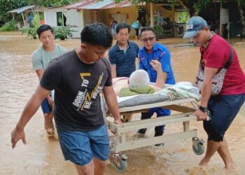 ANGGOTA Angkatan Pertahanan Awam (APM) membantu memindahkan warga emas yang terjejas banjir di Tenom hari ini.