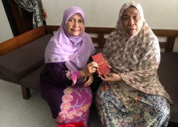DR. Hafidzah Mustakim (kiri) menyerahkan sumbangan yang dikirim Mohd. Na’im Mokhtar kepada Sarimah Mamat di Kampung Semut Api, Kota Bharu, Kelantan hari ini.- UTUSAN/ROSLIZA MOHAMED.