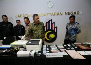 SAIFUDDIN NASUTION iSMAIL menunjukkan dokumen yang dirampas pada sidang akhbar JPN, Putrajaya. - UTUSAN/FAISOL MUSTAFA