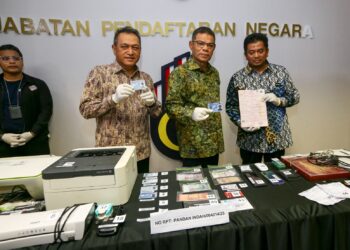 SAIFUDDIN NASUTION iSMAIL menunjukkan dokumen yang dirampas pada sidang akhbar JPN, Putrajaya. - UTUSAN/FAISOL MUSTAFA