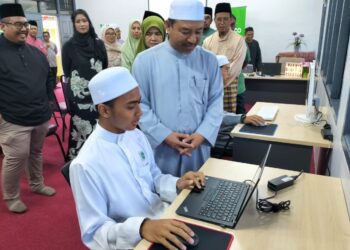 MOHD. Nassuruddin Daud (kanan) beramah mesra dengan pelajar semasa  melawat makmal komputer di SMU (A) Tarbiah Diniah Meranti, Pasir Mas, Kelantan malam tadi-UTUSAN/ROHANA ISMAIL.