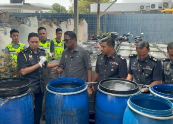 JEGAN (depan, tiga dari kiri) meneliti sebahagian daripada minyak masak bersubsidi 1 kg yang dirampas di Kompleks Penyimpanan KPDN Pulau Pinang, hari ini.-UTUSAN/SITI NUR MAS ERAH AMRAN