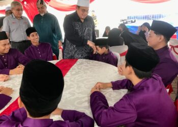 HILMI Abdullah (kanan) bersalaman dengan anak yatim semasa Program CSR Isuzu Iftar Ramadan di Tec United Auto Sdn. Bhd di Kota Bharu, Kelantan semalam.-UTUSAN/ROSLIZA MOHAMED.