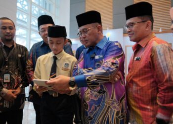 MUHAMMAD Al Fateh Mohd Faizal berpeluang menyemak keputusan UPKK di hadapan Mohd Na'im Mokhtar di Kompleks Islam Putrajaya. - UTUSAN/FAIZ ALIF ZUBIR