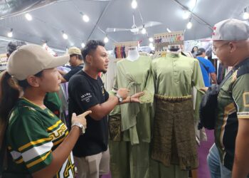 HADZEED Syazwan Hashim (dua dari kanan) menunjukkan baju Melayu jualannya di Bazar Aidilfitri Dataran Senawang, Seremban.-UTUSAN/NOR AINNA HAMZAH.