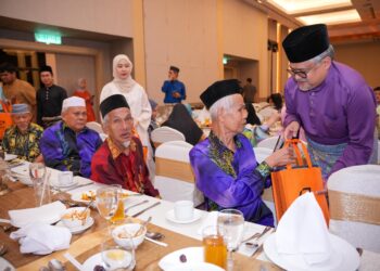 MAHMOOD Razak Bahman menyampaikan duit raya kepada warga emas dari Rumah Seri Kenangan Cheras pada majlis berbuka puasa Puspakom di Shah Alam, Selangor.-UTUSAN/SADDAM YUSOF