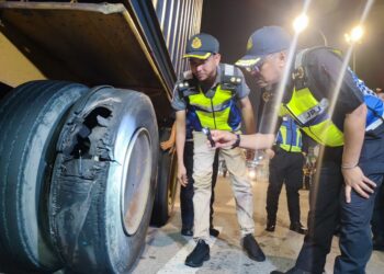 ZULKIFLY Ismail (kanan) menunjukkan keadaan tayar lori yang pecah ketika Ops Khas Hari Raya Aidilfitri (HRA) 2025 di Plaza Tol Juru arah Utara di Pulau Pinang, malam tadi.-UTUSAN/IQBAL HAMDAN