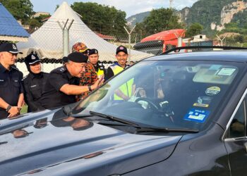 SIK Choon Foo menyerahkan pek makanan kepada pengguna jalan raya di Stesen Penguatkuasaan JPJ Mentara (SPK Mentara), Gua Musang, Kelantan. - UTUSAN/AIMUNI TUAN LAH