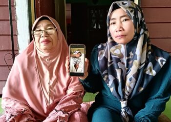 NOR Asmah Mat Isa (kanan) ditemani Som Ali menunjukkan 'Abang belon' kini dirawat di Hospital Serdang, Selangor ketika ditemui di Perumahan Awam Kos Rendah Kuala Tembeling di Jerantut, Pahang. - UTUSAN/HARIS FADILAH AHMAD