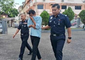 ANGGOTA polis mengiringi Ahmad Syahir Sharifudeen keluar dari Mahkamah Majistret Kemaman, Terengganu, hari ini. -UTUSAN/NIK NUR IZZATUL HAZWANI NIK ADNAN