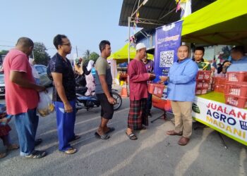 MUHAMAD Fadlee Hassan (kanan) ketika pelancaran jualan Program Semarak Syawal di   Pasar Tani Kekal Nyiur Tujuh, Besut, Terengganu. - UTUSAN / WAN ZURATIKAH IFFAH WAN ZULKIFLI