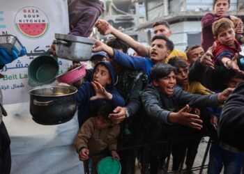 KANAK-kanak Palestin beratur mendapatkan makanan untuk berbuka puasa daripada dapur amal di Beit Lahia, utara Gaza.- AFP