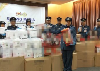 SUZANA Sarif (depan) menunjukkan periuk nasi dan pengisar yang dirampas JKDM Perak dalam serbuan berasingan di ICIC Pelabuhan Klang, Selangor baru-baru ini. - UTUSAN