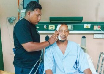 AZLAN Mahmood ditemani anak bongsunya, Muhd. Aliff selepas menjalani pembedahan mengeluarkan besi pada bahagian muka 
di  Sungai Petani, Kedah.