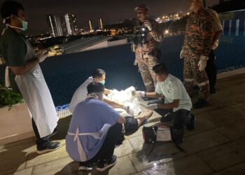 PASUKAN perubatan memeriksa remaja lelaki yang ditemukan lemas di kolam renang sebuah kondominium di Meru, Ipoh semalam. - UTUSAN