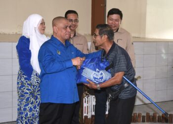 SAARANI Mohamad menyampaikan sumbangan bakul makanan kepada penerima pada Program Santunan Kasih Kerajaan Negeri Perak di Air Kuning di Tapah hari ini. - UTUSAN/ZULFACHRI ZULKIFLI