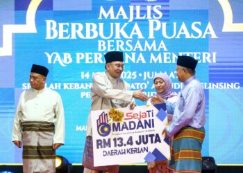 ANWAR Ibrahim menyampaikan replika cek Sejati Madani untuk Daerah Kerian pada Majlis Berbuka Puasa Madani Peringkat Negeri Perak di Sekolah Kebangsaan Dato’ Alauddin, Selinsing di Bagan Serai hari ini. - UTUSAN/MUHAMAD NAZREEN SYAH MUSTHAFA