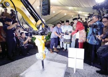 ANWAR Ibrahim melakukan gimik perasmian pada Majlis Pecah Tanah Pembangunan Masjid Madani di Jalan Munshi Abdullah, Kuala Lumpur, semalam. – UTUSAN/SHIDDIEQIIN ZON