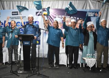 MUHAMMAD Sanusi Md. Nor (tengah) mengibarkan bendera PN pada pelancaran jentera parti untuk PRK Ayer Kuning di Tapah semalam. - UTUSAN/ZULFACHRI ZULKIFLI