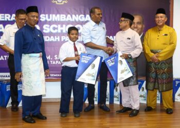 M. SARAVANAN menyampaikan sumbangan keperluan persekolahan kepada penerima di Pejabat Pendidikan Daerah Batang Padang di Tapah. - UTUSAN/mUHAMAD NAZREEN SYAH MUSTHAFA