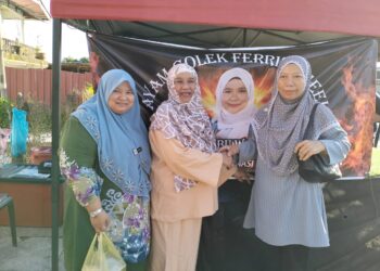 WAN Maimunah (dua dari kriri) ketika membantu anaknya berniaga di gerai ayam golek 'Ferris Wheel' di Kampung Wakaf Beruas, Kuala Terengganu. - UTUSAN/KAMALIZA KAMARUDDIN