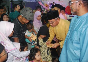 ADLY Zahari (dua dari kanan) memberikan duit raya kepada kanak-kanak pada Jamuan Aidilfitri DUN Bukit Katil di Dewan Datuk Demang Hussin, Bukit Katil, Melaka. UTUSAN/AMRAN MULUP