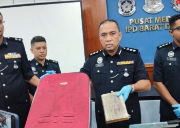 SAZALEE Adam (dua dari kanan) menunjukkan beg dan ketulan ganja yang dirampas dalam dua serbuan di daerah Barat Daya dan Timur laut di Pulau Pinang, semalam. - UTUSAN/IQBAL HAMDAN