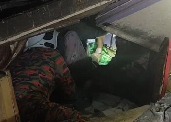 ANGGOTA bomba membantu membawa keluar wanita warga emas yang kakinya dihempap dalam runtuhan rumah di Lawas, Sarawak awal pagi tadi