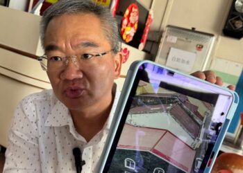 KHOO Poay Tiong menunjukkan gambar sebuah bangunan warisan di Jalan Tokong, Banda Hilir, Melaka yang didakwa struktur asalnya telah diubah suai tanpa mematuhi garis panduan ditetapkan.