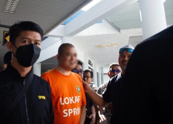 SUSPEK diiringi pegawai SPRM ketika hadir ke Mahkamah Majistret,
Ayer Keroh, Melaka untuk permohonan reman. – UTUSAN/ARIF
HAMIZAN