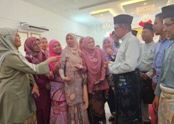 ADNAN Mat (tiga dari kanan) beramah mesra bersama penjawat awam yang hadir pada Majlis Sambutan Syawal Ceria Madani di Kuala Terengganu, hari ini. - UTUSAN/ZAID MOHD. NOOR