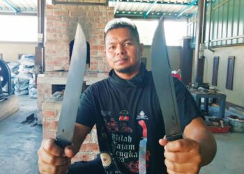 MOHD. WALID JALALUDDIN Abu Osman menunjukkan pisau ditempah pelanggannya di Kampung Gong Nangka, Marang, Terengganu. – UTUSAN/NOOR HAYATI MAMAT