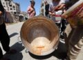 PENDUDUK Palestin mencari sisa makanan dalam periuk masakan di sebuah dapur amal di kem pelarian Bureij, tengah Semenanjung Gaza.-AFP