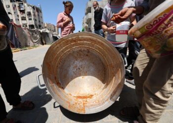 PENDUDUK Palestin mencari sisa makanan dalam periuk masakan di sebuah dapur amal di kem pelarian Bureij, tengah Semenanjung Gaza.-AFP