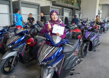 NOORHASLIZAWATI menerima dua buah motosikal yang diserahkan di pekarangan
Stesen LRT Putra Heights, Subang Jaya, Selangor.