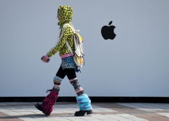SEORANG wanita berjalan melepasi sebuah kedai Apple di Beijing, China.-AFP
